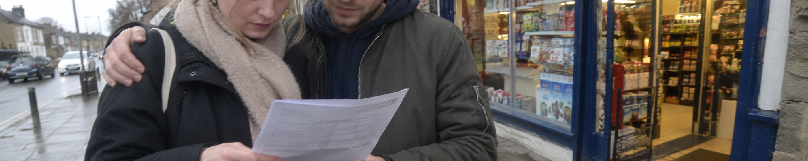 Two people reviewing information together outside a local shop.