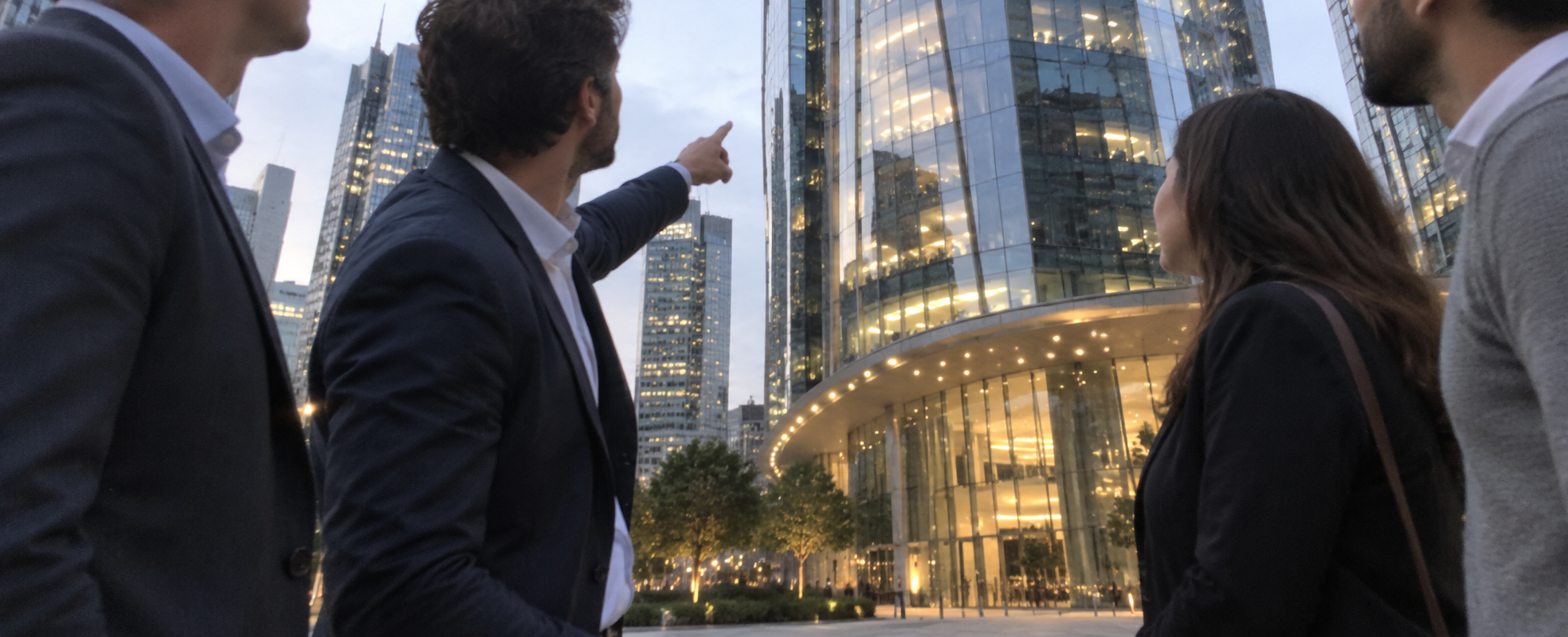 A business team looking towards a modern office building.